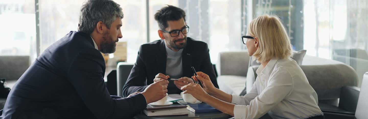 three people around a desk